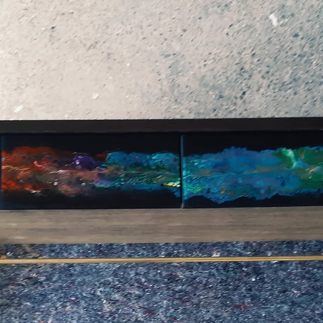 Console vue de face, deux façades de tiroirs en résine époxy bleue, verte et rouge, tringle en laiton